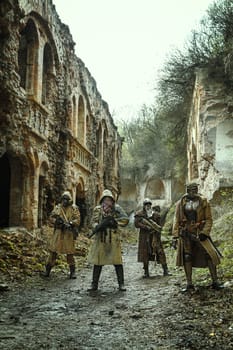 Nuclear post-apocalypse. Survivors in tatters and gas mask on the ruins of the destroyed city