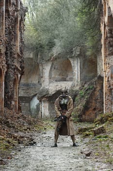 Nuclear post-apocalypse. Sole survivor in tatters and gas mask on the ruins of the destroyed city