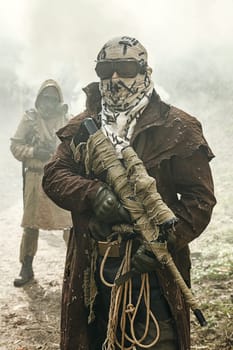 Nuclear post-apocalypse. Survivors in tatters and gas mask on the ruins of the destroyed city