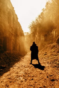 Nuclear post-apocalypse. Sole survivor in tatters and gas mask on the ruins of the destroyed city