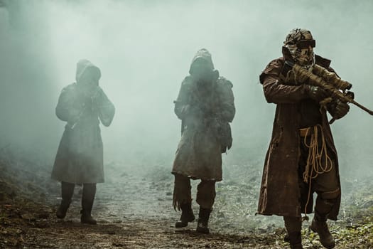Nuclear post-apocalypse. Survivors in tatters and gas mask on the ruins of the destroyed city