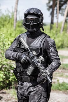 Spec ops police officer SWAT in black uniform in action