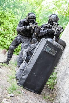 Spec ops police officers SWAT in black uniform in action