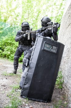 Spec ops police officers SWAT in black uniform in action