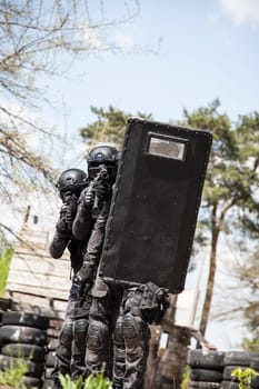 Spec ops police officers SWAT in black uniform in action