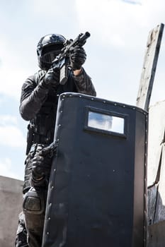 Spec ops police officers SWAT in black uniform in action