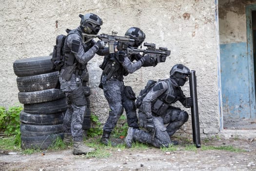 Spec ops police officers SWAT in black uniform in action