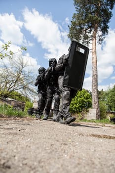 Spec ops police officers SWAT in black uniform in action