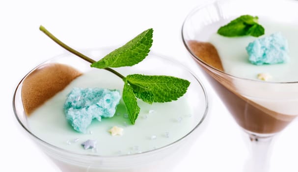 chocolate mint panna cotta in glass glasses, garnished with blue molecular biscuit