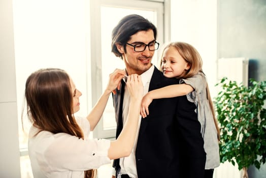 Happy little girl play with her mother and father on the sofa