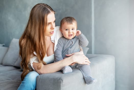 Little child smiling and happy with mom on the sofa