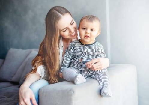 Little child smiling and happy with mom on the sofa