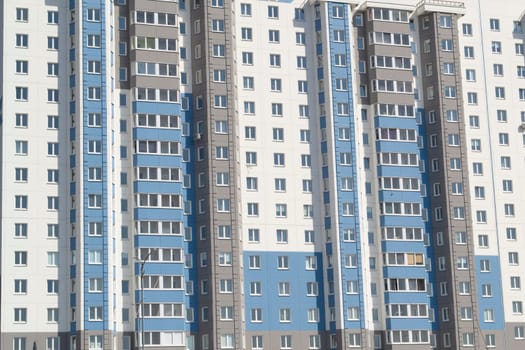 Multiple windows on a large building in the city in blue and white