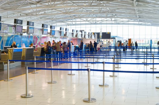 LARNACA, CYPRUS - FEBRUARY 21, 2019: Peopel at chekin desks and terminal of Larnaca International airport, modern interior