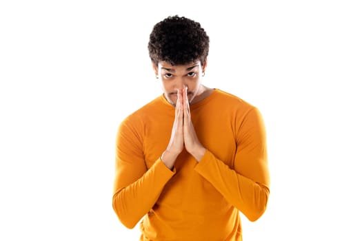 Cute african american man with afro hairstyle wearing a orange T-shirt isolated on a white background