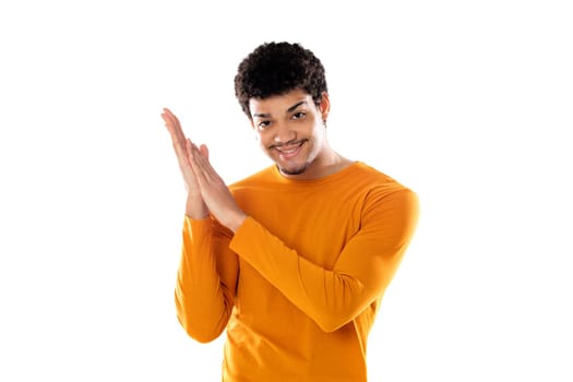 Afro guy wering a orange sweater clapping isolated on a white background