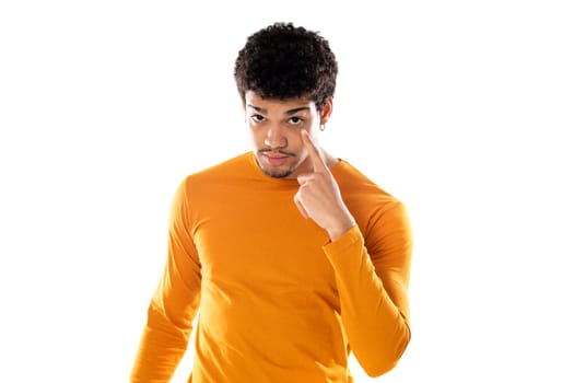 Cute african american man with afro hairstyle wearing a orange T-shirt isolated on a white background