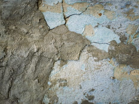 Weathered and cracked concrete wall maintained through time with blue lime and different mortar mixes. Peeling plaster from cement structure surface. Construction element, abstract texture background.