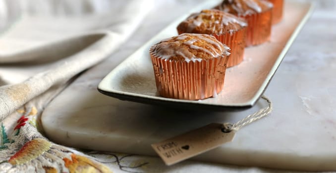 Sweet pastries,powdered sugar, Sweet cakes on marble. Cup cakes on a kitchen table. Vintage sweets, vintage tablecloth with embroidery on linen fabric, gift tag for mock up