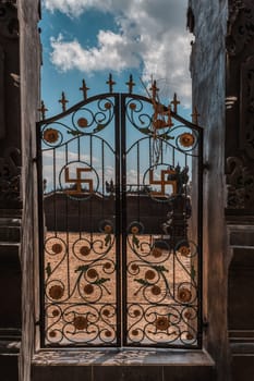 entry to Hindu Temple, iron gate decorated with swastika symbols. Kampung Toyapakeh in Nusa Penida island, Bali, Indonesia