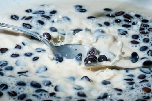 Coffee beans falling on the milk splash. Cup of milk. Concept photography.