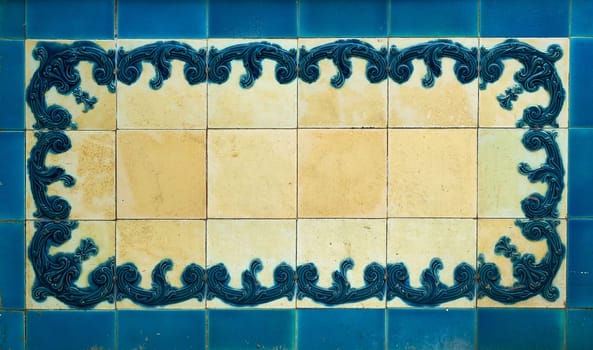 The elaborate design on the tiles is embossed and stained blue. The white areas are worn and stained yellow.