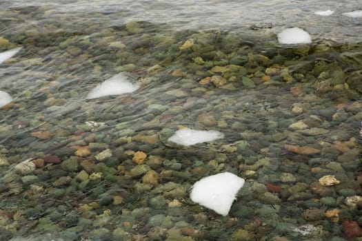 crystal clear water on Lake Teletskoye, through which you can see the stones lying on the bottom.Russia, Altai Krai.