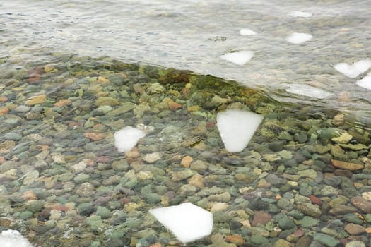 crystal clear water on Lake Teletskoye, through which you can see the stones lying on the bottom.Russia, Altai Krai.
