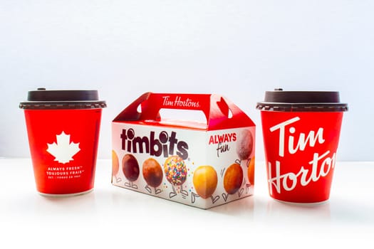 Calgary, Alberta Canada. May 7, 2021. A couple of Tim Hortons coffee cups with a timbits box.