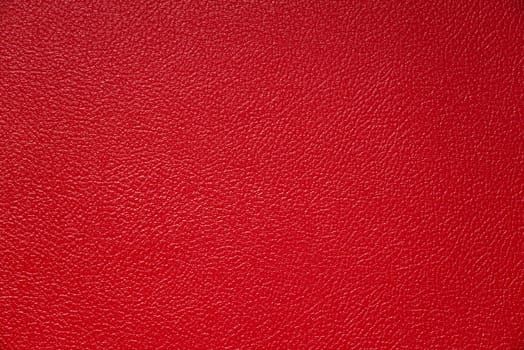 The subtle texture of red vinyl tolex on a guitar amp speaker cabinet.