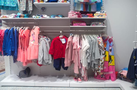Spain, Badajoz - April 14th, 2018: Multicolored children clothing on the shelves of department store