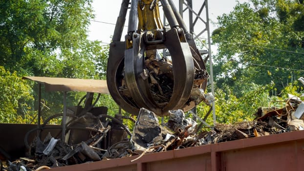 Hydraulic claw lifting and destroying metal on scrapyard