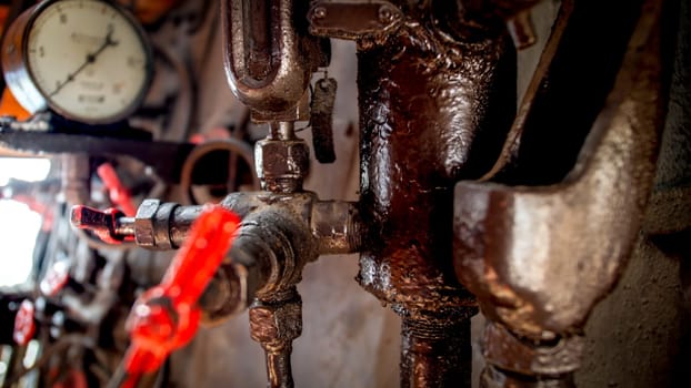 Closeup image of pipes, tubes, vavlves and gauges on steam power engine at old locomotive