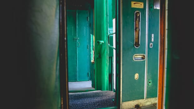 Toned photo of open doors in corridor of vintage steam express trian