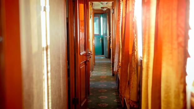 Interior of retro steam train car with wooden doors and carpets on floor