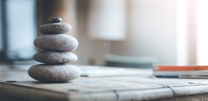 Feng Shui: Stone cairn in the foreground, blurry living room in the background. Balance and relaxation.