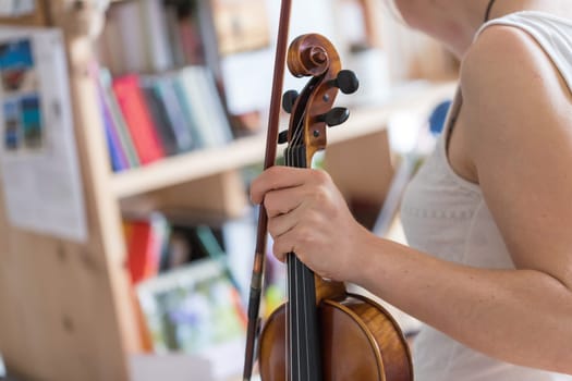 Pretty young girl practices on her violin, acoustic music