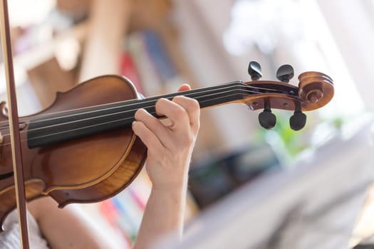 Pretty young girl practices on her violin, acoustic music