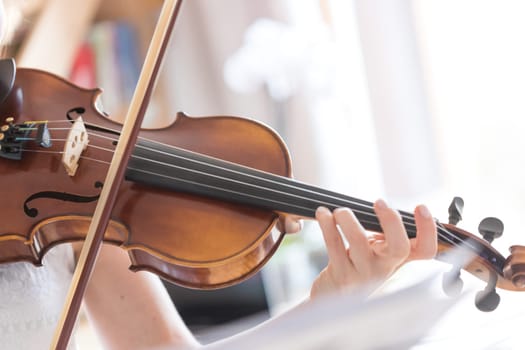 Pretty young girl practices on her violin, acoustic music