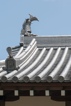 Japanese temple roof tiles against blue sky
