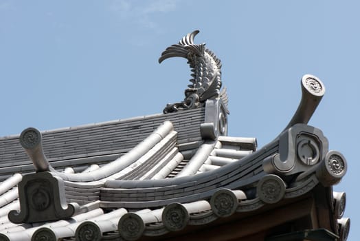 Japanese castle roof tiles against blue sky