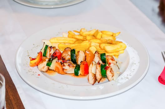 Shashlik skewer with chicken meat and fries