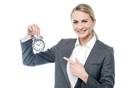 Female executive pointing her finger at alarm clock