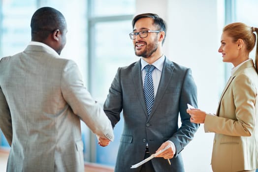 Happy businessmen handshaking after striking deal