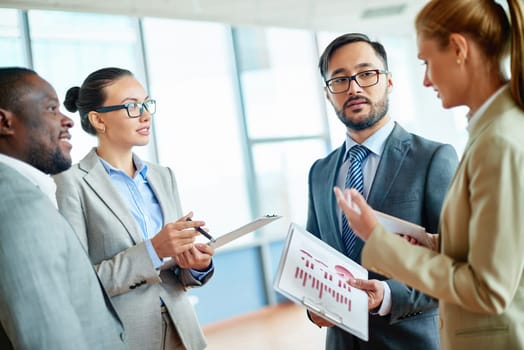 Group of elegant colleagues communicating at meeting
