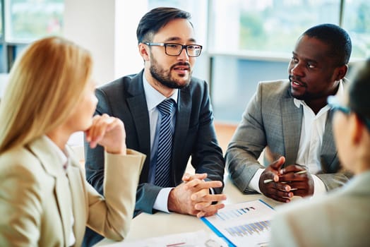 Serious businessman explaining his ideas to managers at meeting