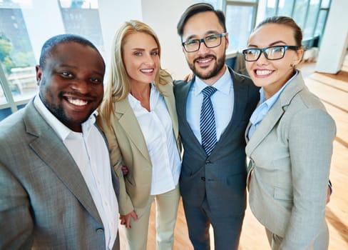 Happy business partners in formalwear looking at camera in office