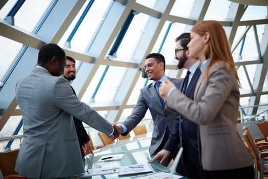 Business partners handshaking upon striking deal in office