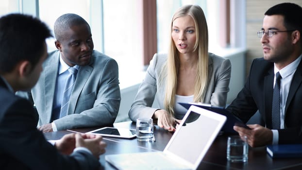 Pretty businesswoman explaining her idea to colleagues at meeting