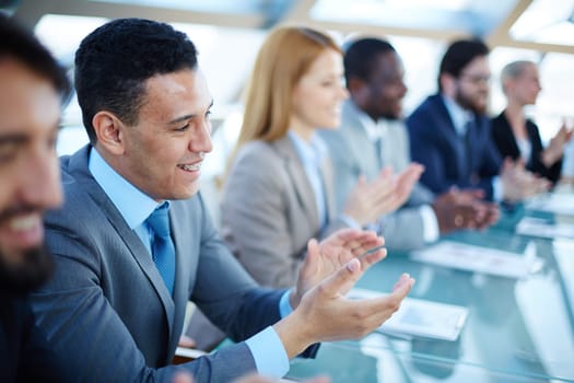 Happy business people applauding to speaker at seminar
